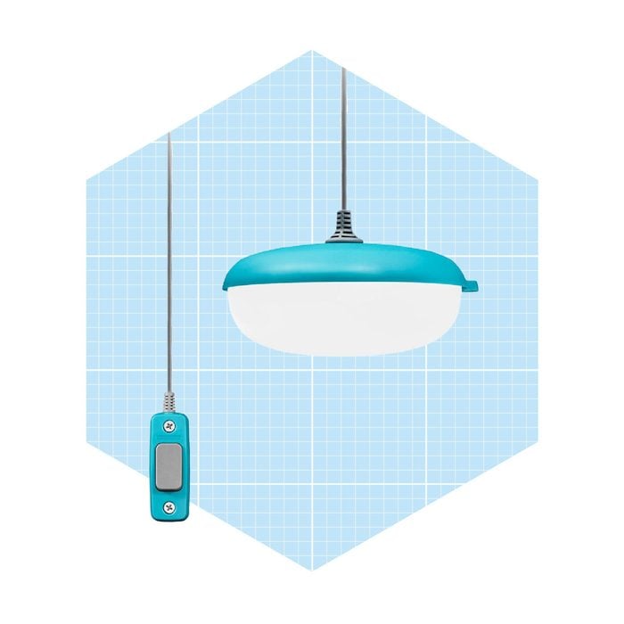 A teal and white pendant lamp hangs from a ceiling wire, with a switch attached by cable, set against a light blue grid background.