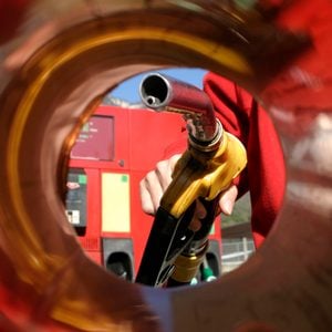 View from inside a car's gas tank intake with a gas pump entering it