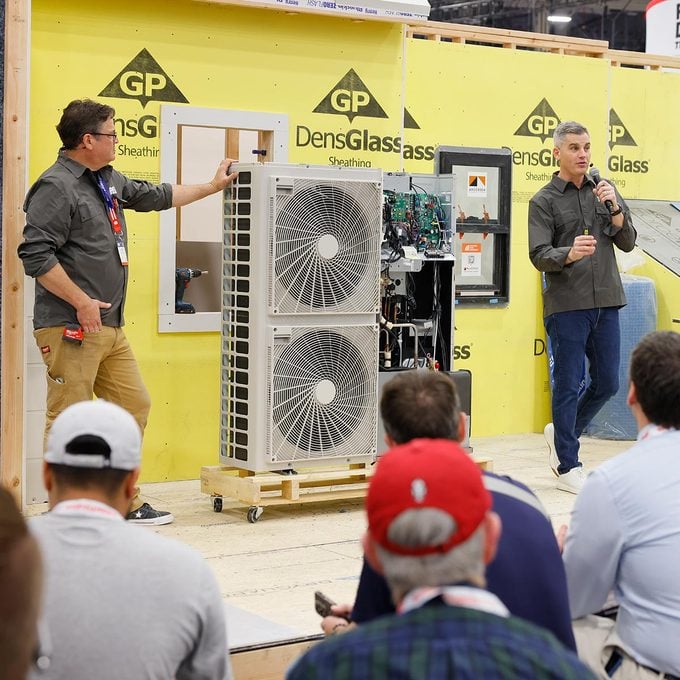 Two men present an air conditioning system at the NABH International Builders Show
